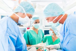Hospital - surgery team in operating room or Op of a clinic operating on a patient in an emergency situation